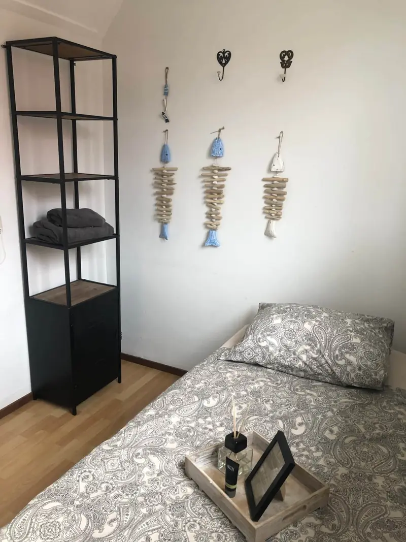 Eenpersoonskamer met een zwart wandrek en houten decoraties