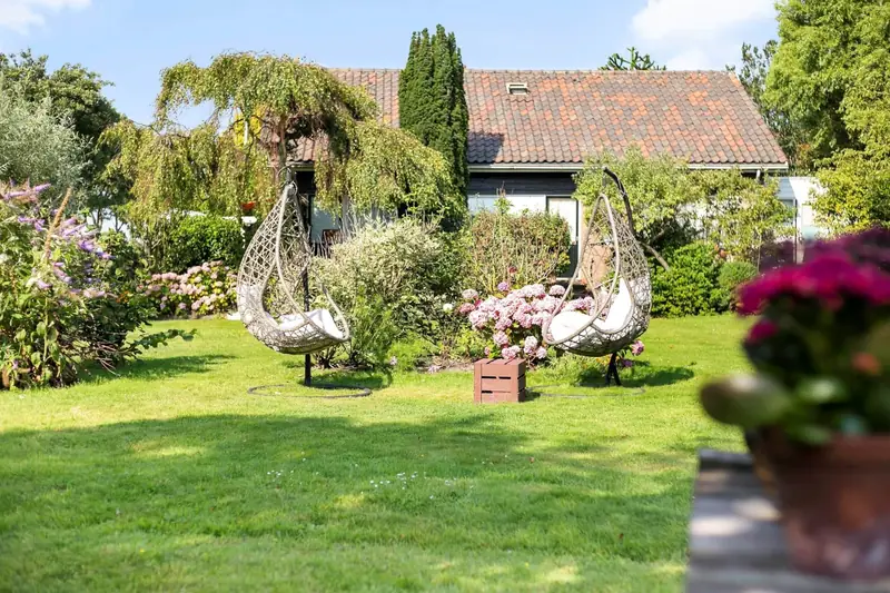 Hangstoelen tussen de bloemen in de tuin